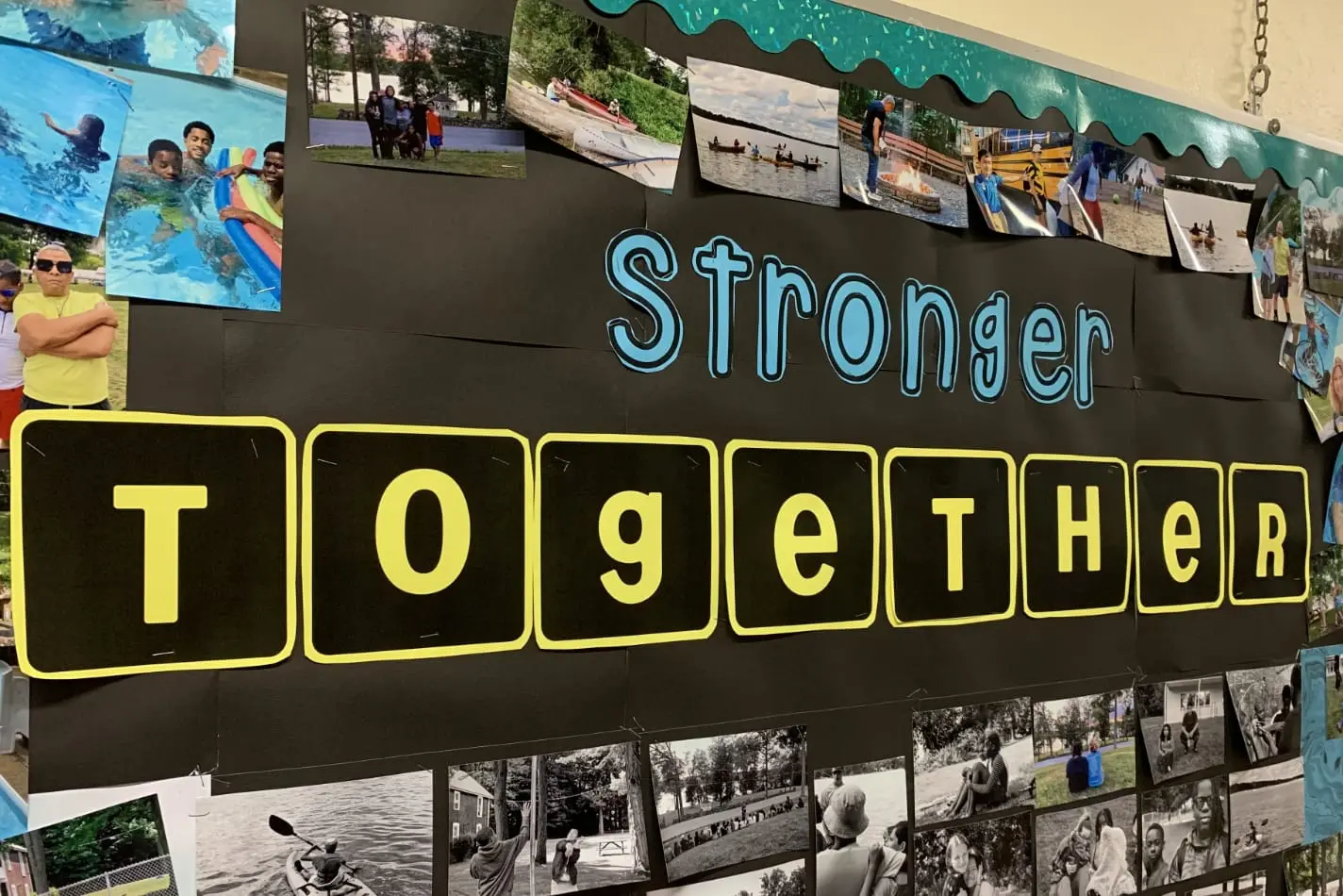 A bulletin board display that reads 'Stronger Together' surrounded by photos of Nativity students