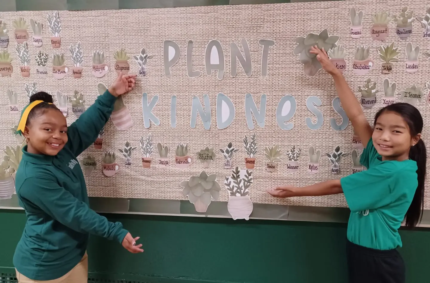 Two Nativity Prep students in front of a decorated bulletin board